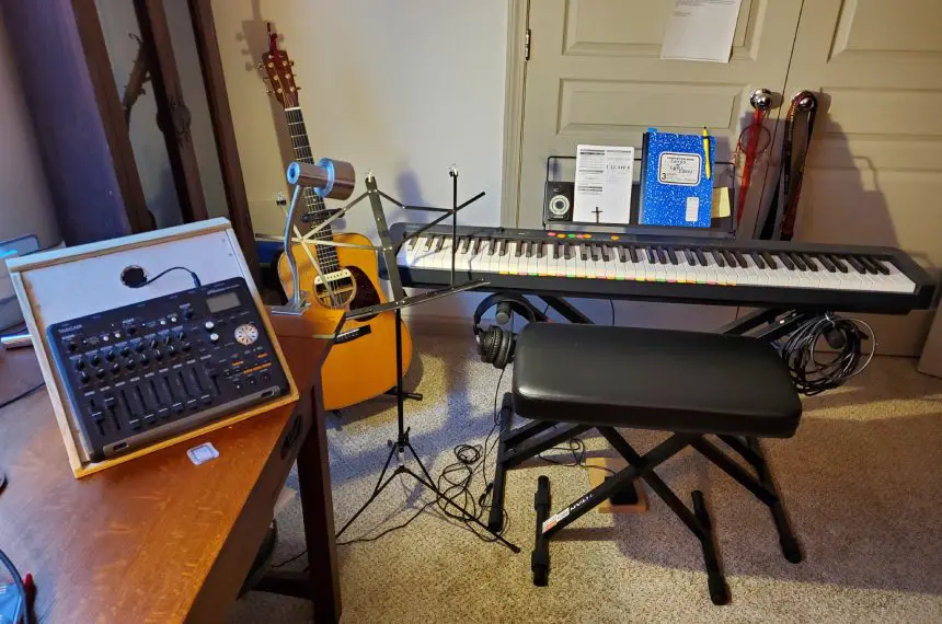 A room with a keyboard, guitar and other musical instruments.