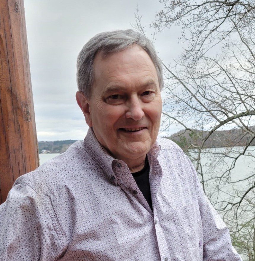 A man standing in front of a body of water.